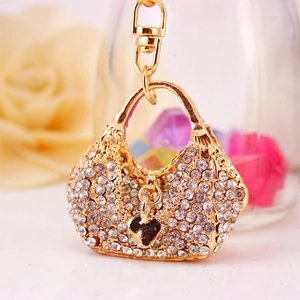 Golden handbag keychain with white rhinestones and a black heart charm pendant