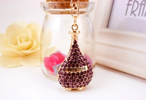 Macro view of purple rhinestone encrusted perfume bottle keychain with gold Parfum detail