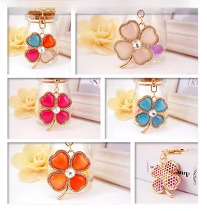 Detailed views of crystal four-leaf clover keychains with opal stone and rhinestones