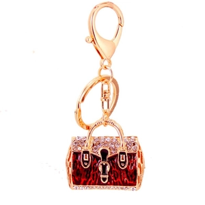 Golden handbag keychain with red leopard print pattern and sparkling white rhinestones