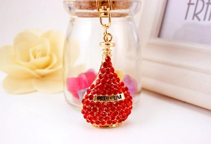Macro shot of a luxury red rhinestone perfume bottle keychain with gold PARFUM lettering