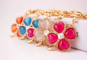 Close-up of sparkling rhinestone heart-shaped cat-eye clover keychain with gold alloy