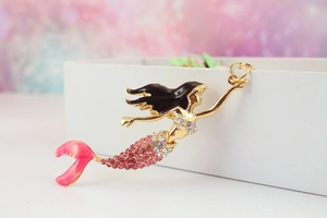 Detailed view of mermaid keychain with pink crystals and golden metal ring