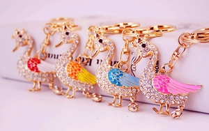 Macro shot of colorful swan keychains with rhinestone inlay and gold-plated details