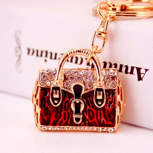 Exquisite golden handbag keychain with red leopard enamel and sparkling rhinestones