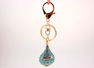 Macro shot of sky blue rhinestone perfume bottle keychain with PARFUM engraving