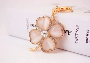 Detailed macro view of the four-leaf clover keychain featuring pink opal and sparkling crystals