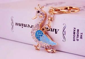 Detail of peacock keychain with gold plating, white rhinestones and blue enamel details
