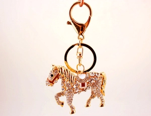 Close-up of golden horse keychain with sparkling rhinestones and lobster clasp