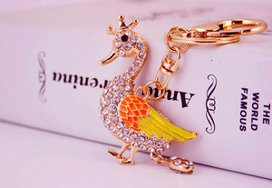 Macro detail of a sparkling swan keychain with rhinestones and enamel wings decoration
