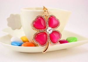 Close-up of pink opal four-leaf clover keychain with gold plating and zircons