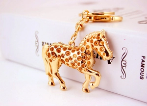 Detailed macro view of the gold-plated horse keychain with intricate cut-out patterns