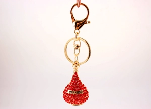 Detailed view of perfume bottle keychain with red rhinestones and gold Parfum band