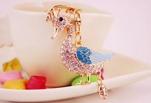 Close-up of crown swan keychain with blue gradient enamel and sparkling rhinestones