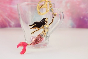 Detailed macro view of golden mermaid keychain featuring pink rhinestones and lobster clasp