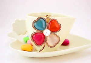 Detail of four-leaf clover keychain with rhinestones and colorful opal hearts