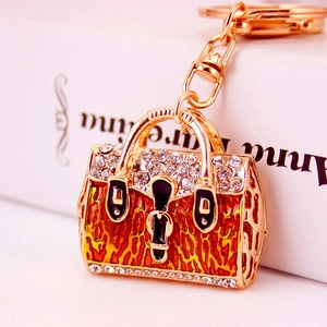 Golden handbag keychain with orange leopard enamel and rhinestones on book