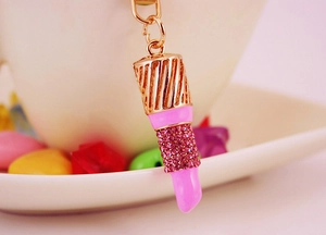 Detalle de llavero con forma de lápiz labial con cristales rosas y toques dorados