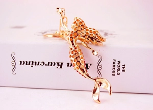 Detailed view of golden mermaid keychain with gradient orange and red sparkling rhinestones