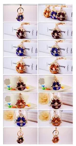 Detail view of colorful enamel fish keychains with bells in blue, red, and yellow options