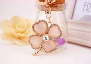 Close-up of pink opal four-leaf clover keychain with rose gold plating and crystal rhinestones