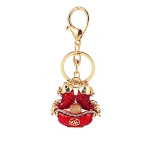 Detail of red koi fish keychain with cat-eye bead and gold Fu character on ingot