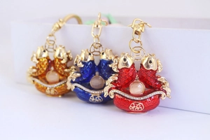 Detail view of colorful koi fish keychains with fortune charms and cat eye stones