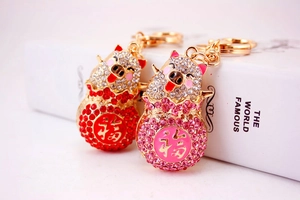 Macro detail of diamond-encrusted pig keychains with Fu character and gold alloy plating