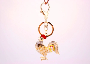 Détail d'un porte-clés coq avec pierres œil-de-chat, émail coloré et strass brillants