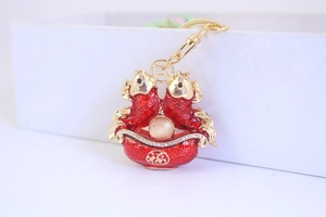 Detailed macro view of the carp keychain with red enamel and lucky treasure basin charm