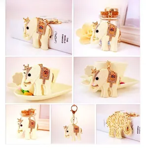Detailed views of an elephant keychain with crown, gemstone saddle, and gold buckle