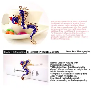 Detailed views of a gold dragon keychain with blue rhinestones and dimensions shown