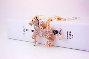 Close-up of golden horse keychain featuring sparkling crystals and enamel mane details