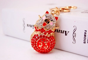 Close-up of a golden pig keychain with red rhinestones and a Fu character pendant