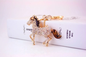 Detail of horse-shaped keychain with sparkling rhinestones and golden spring clasp