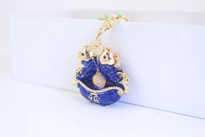 Detailed shot of double carp keychain with blue enamel, crystals and lucky coin charm