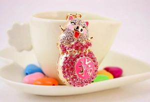 Detail of a sparkling crystal-encrusted pig keychain with a Fu character charm and pink rhinestones