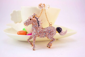 Detail of creative horse keychain with rhinestones and black white enamel details