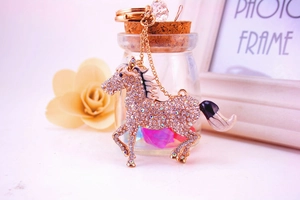 Detail view of rose gold horse keychain with white rhinestones and black enamel accents
