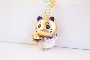 Vue macro du porte-clés chat porte-bonheur doré avec émail bleu et strass