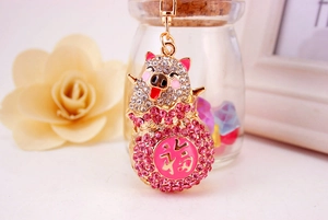 Close-up of golden lucky pig keychain with pink rhinestones and Chinese Fu character