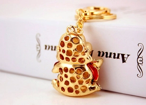 Detail of a golden auspicious beast keychain with hollowed-out design and horseshoe buckle