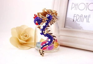Detailed view of a golden Chinese dragon keychain with blue crystals and red accents