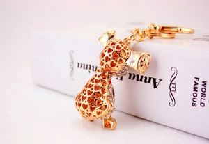Detailed macro view of golden dog keychain with sparkling white crystals and heart cut-outs