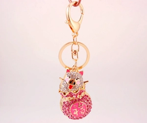 Close-up of a sparkling gold pig keychain with rhinestones and a red Fu character charm
