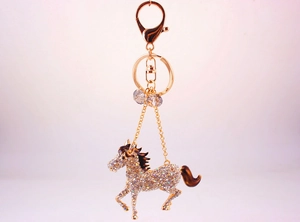 Detailed view of horse keychain with white rhinestones and brown enamel finish
