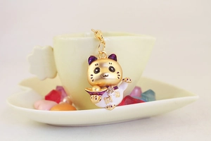 Vue détaillée du porte-clés chat porte-bonheur avec lingots d'or sur une tasse