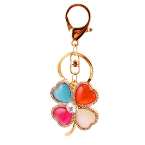 Colorful four-leaf clover keychain with rhinestones and cat eye stones in gold plating