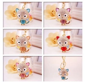 Macro detail of cartoon cat keychains with colorful crystals and golden alloy rings