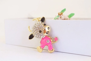 Macro detail of cartoon cow keychain with pink enamel finish and sparkling crystals